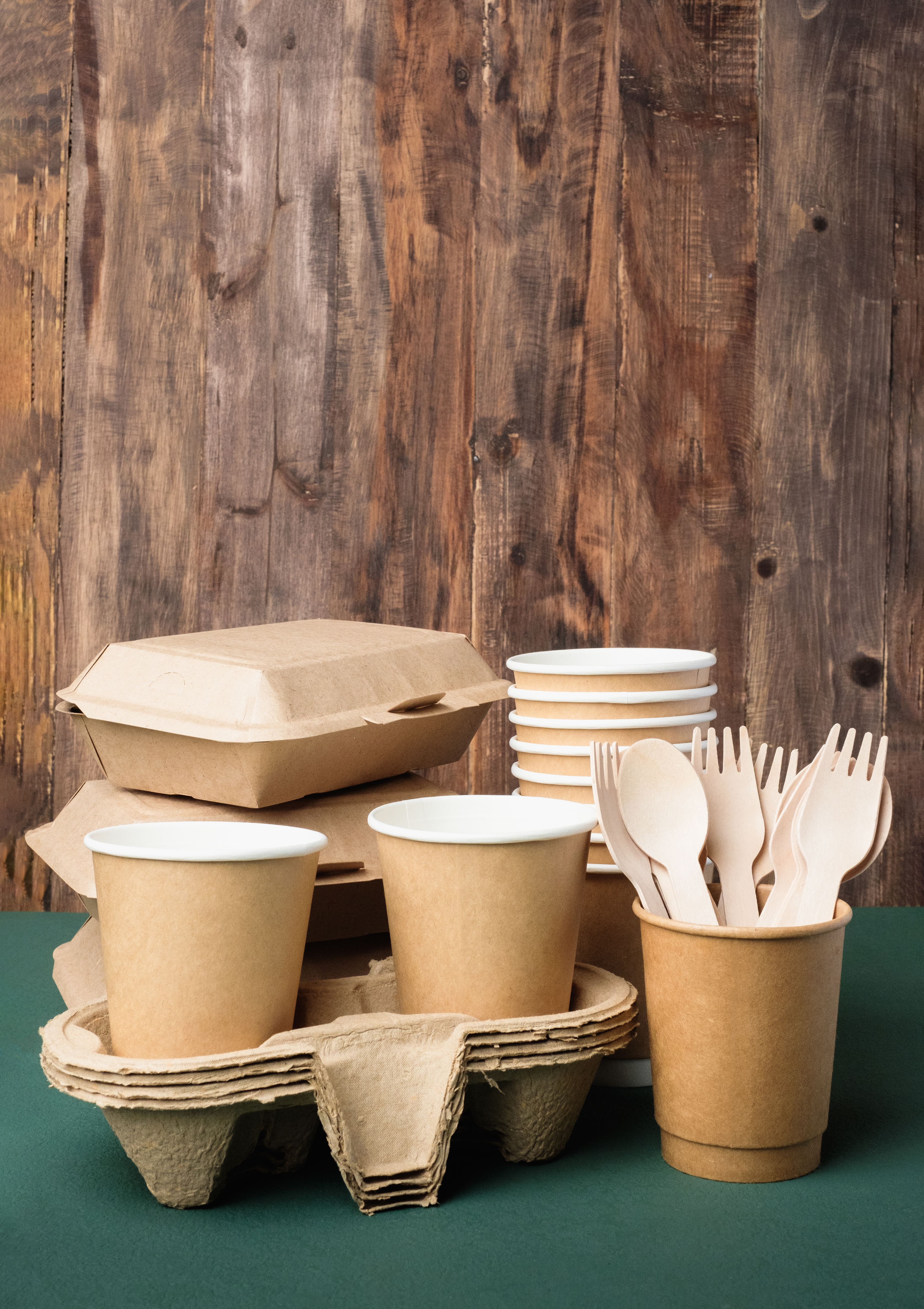 Eco friendly food ware,disposable cup ,food container, bamboo spoon fork on green table.sustainable